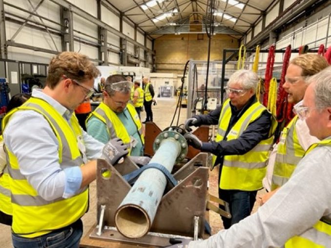 Group looking at a pipe